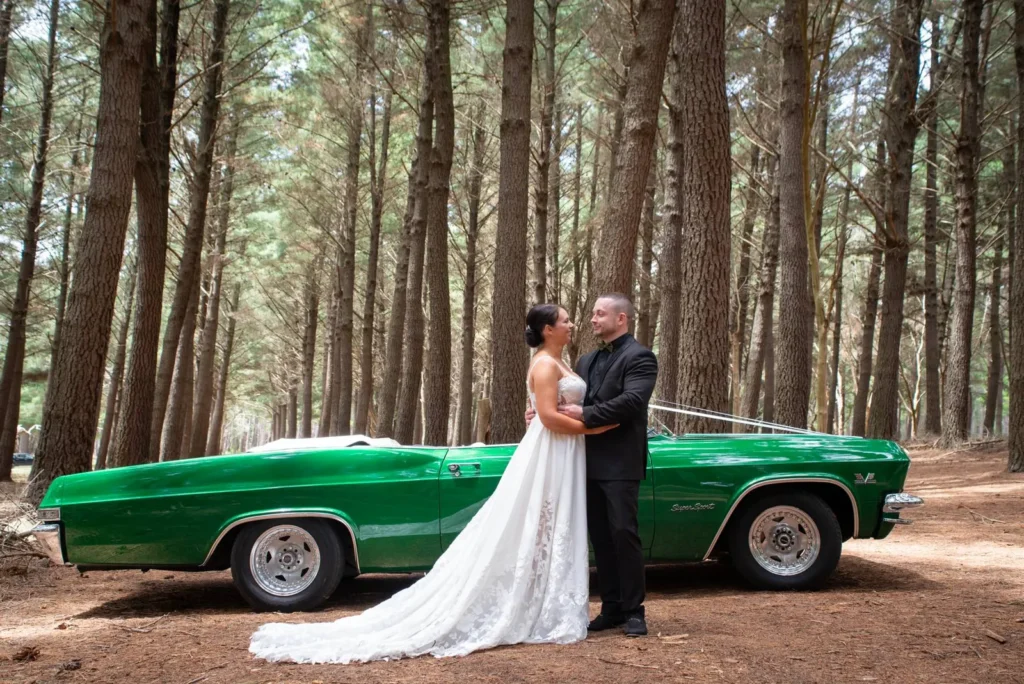 Bride and groom beside a green vintage car in a pine forest, Adelaide wedding by Kalf Productions