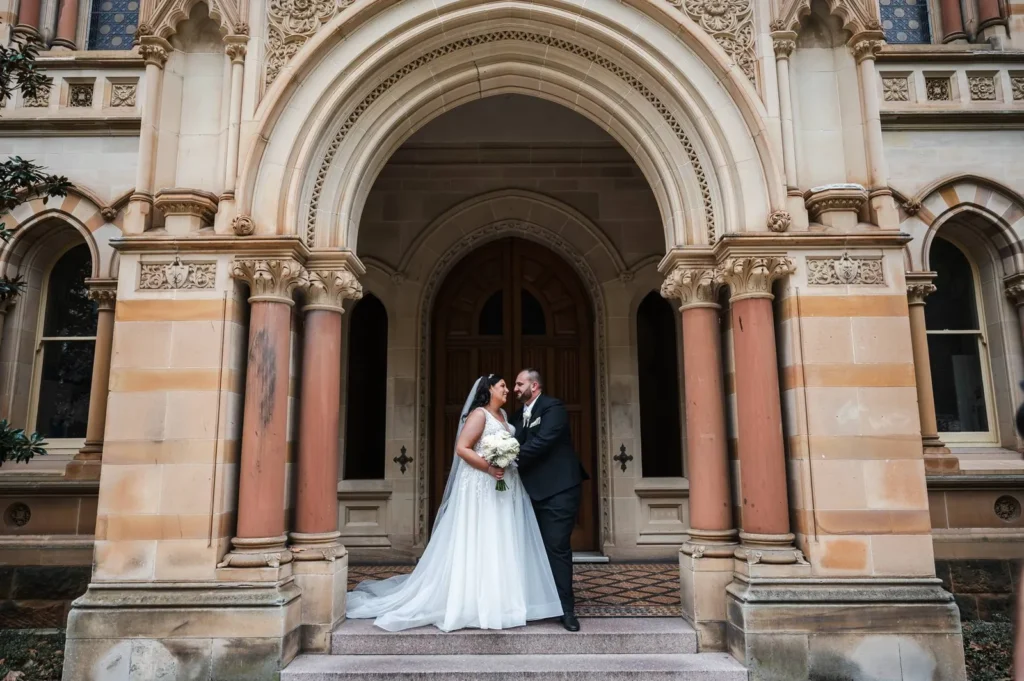 Bride and groom under a sandstone archway in Adelaide